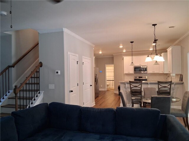 2647 Old Snapping Shoals Rd, Mcdonough, GA 30252 - living room with crown molding, wood finished floors, stairs, recessed lighting, and baseboards