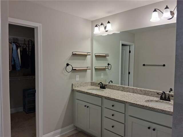 2647 Old Snapping Shoals Rd, Mcdonough, GA 30252 - bathroom with double vanity, a walk in closet, and baseboards