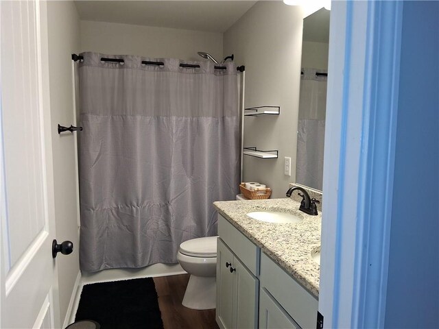 2647 Old Snapping Shoals Rd, Mcdonough, GA 30252 - bathroom featuring toilet, vanity, wood finished floors, and shower / bath combo with shower curtain
