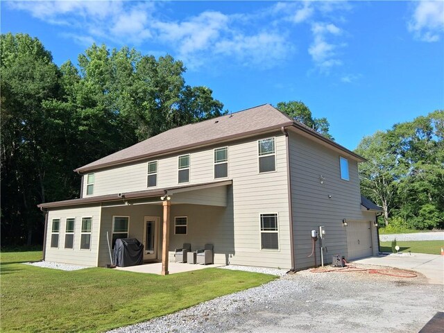 2647 Old Snapping Shoals Rd, Mcdonough, GA 30252 - back of house with driveway, an attached garage, a yard, and a patio