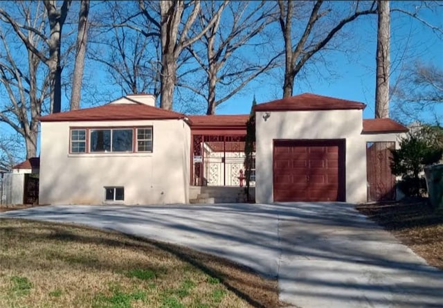 view of front of house featuring an attached garage, driveway, and stucco siding