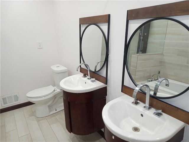 bathroom with baseboards, visible vents, a sink, and toilet