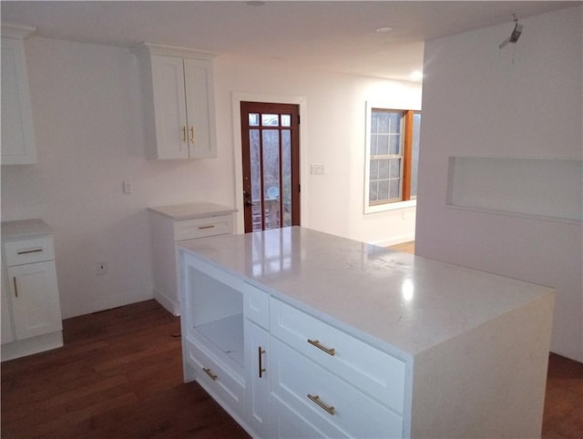 kitchen with a kitchen island, white cabinets, dark wood-style flooring, and light countertops