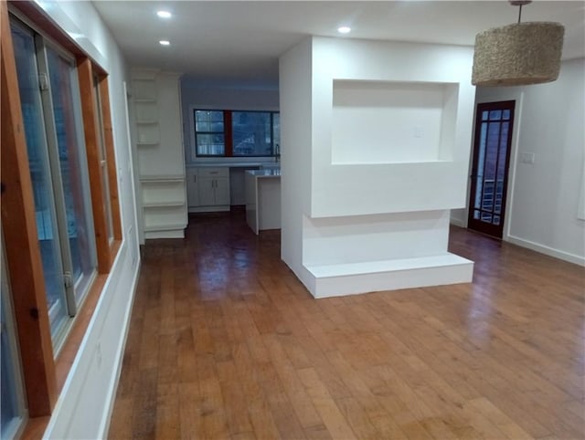 hall with baseboards, wood finished floors, and recessed lighting