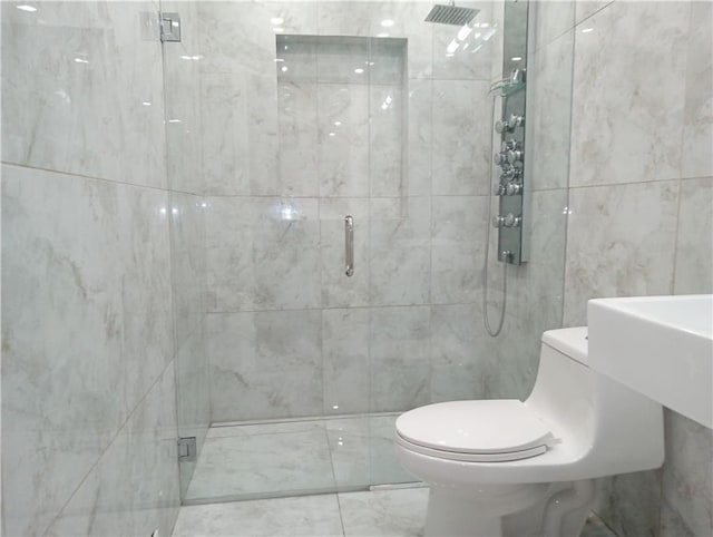 full bath featuring a stall shower, tile walls, and toilet