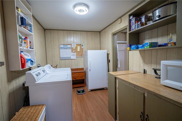67 Dixie Park Rd, Rome, GA 30165 - laundry area featuring light wood-style flooring, washing machine and clothes dryer, wood walls, and cabinet space