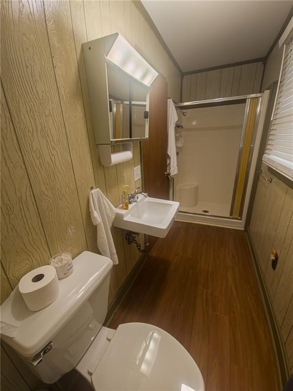 67 Dixie Park Rd, Rome, GA 30165 - bathroom featuring a shower stall, wooden walls, and wood finished floors