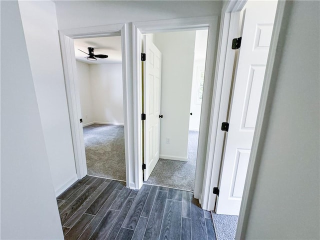 corridor featuring dark colored carpet