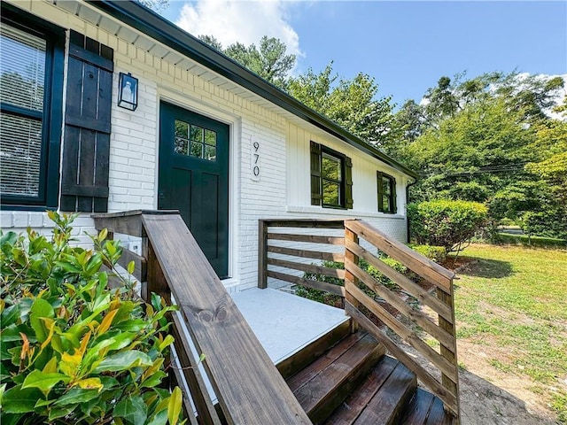 doorway to property with a lawn