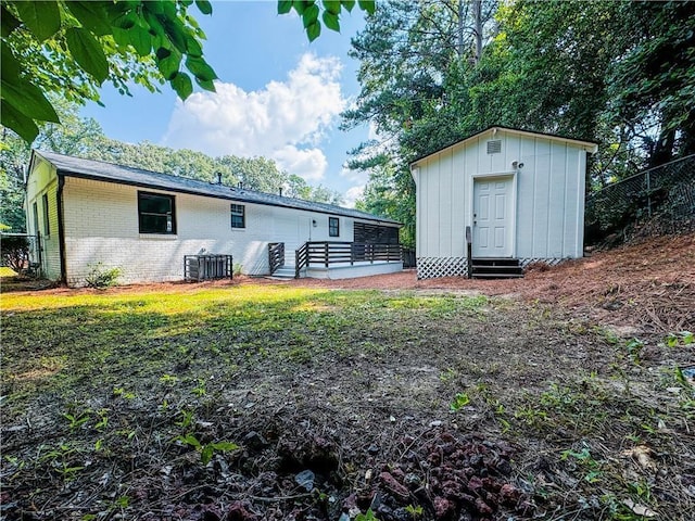 rear view of house with a storage shed and a yard