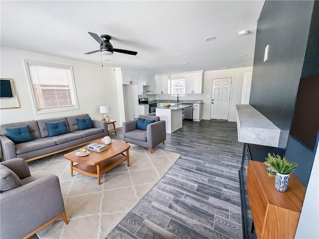 living room with ceiling fan, dark hardwood / wood-style flooring, and sink