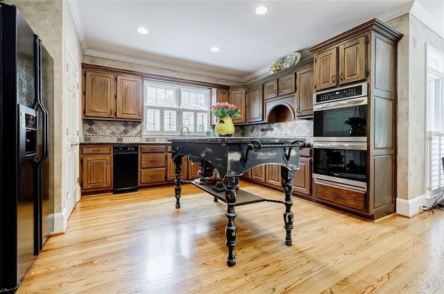 5318 Brooke Farm Dr, Dunwoody, GA 30338 - kitchen with black fridge with ice dispenser, stainless steel double oven, ornamental molding, light wood-type flooring, and dark countertops