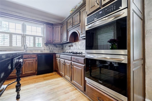 5318 Brooke Farm Dr, Dunwoody, GA 30338 - kitchen with stainless steel appliances, dark countertops, light wood-type flooring, backsplash, and ornamental molding