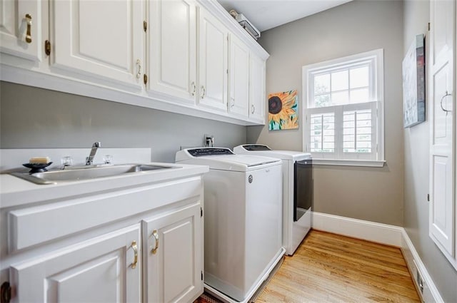 5318 Brooke Farm Dr, Dunwoody, GA 30338 - laundry area with cabinet space, independent washer and dryer, light wood-type flooring, and baseboards