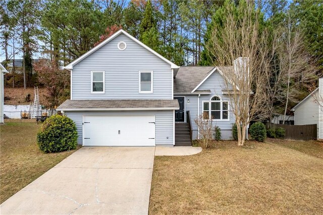 view of front of property featuring a garage, concrete driveway, a front yard, and fence