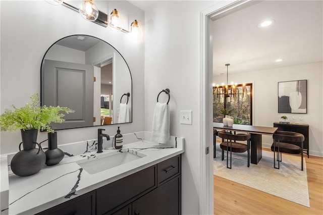 bathroom featuring vanity, a notable chandelier, and hardwood / wood-style flooring