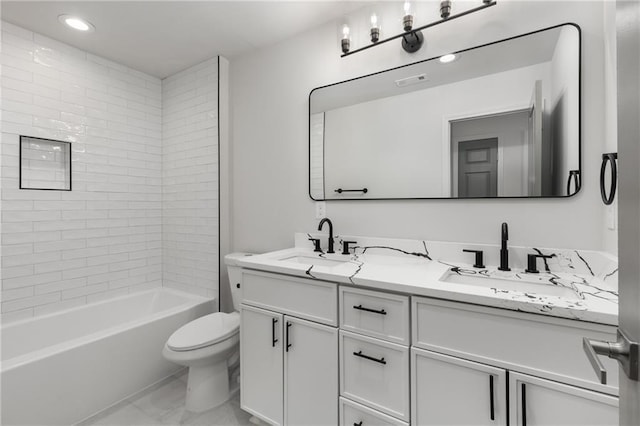 full bathroom with vanity, tiled shower / bath combo, and toilet