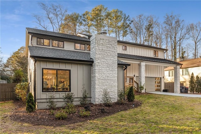 back of house with a garage and a lawn