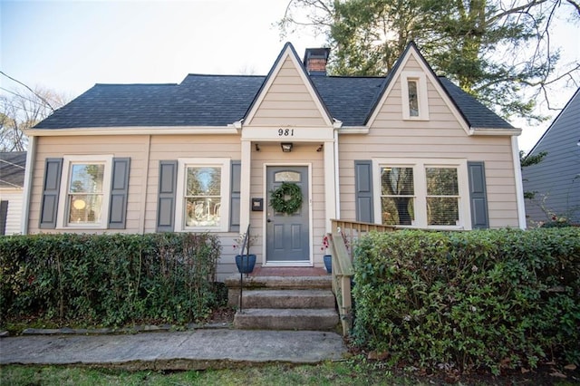 bungalow-style home featuring a shingled roof and a chimney