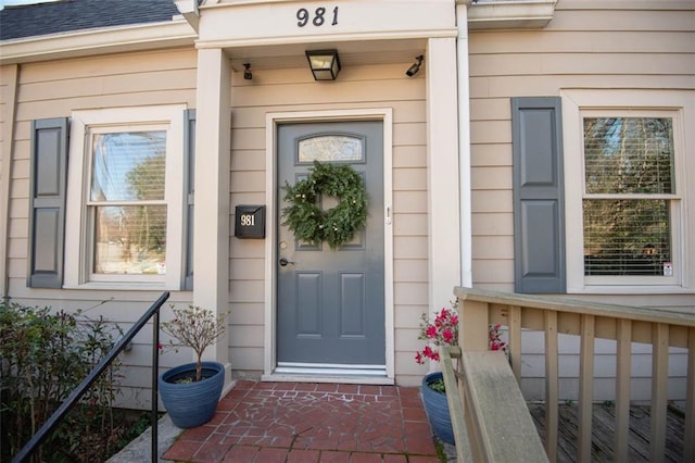 doorway to property featuring a shingled roof