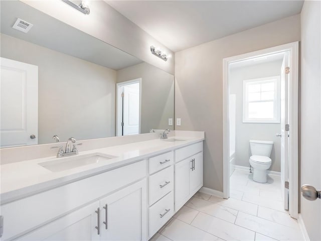 bathroom with vanity, a washtub, and toilet