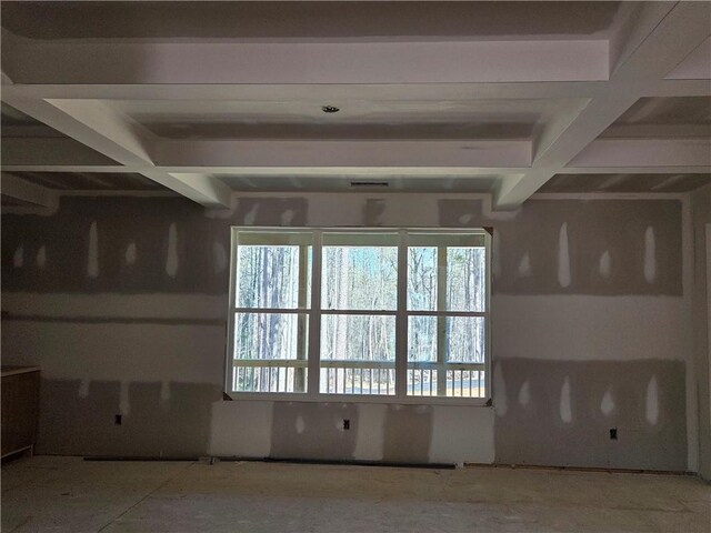 unfurnished living room featuring beamed ceiling, coffered ceiling, and light wood-type flooring