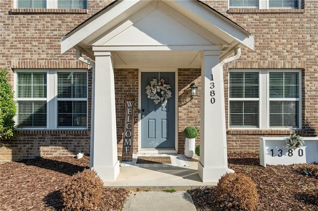 doorway to property with brick siding