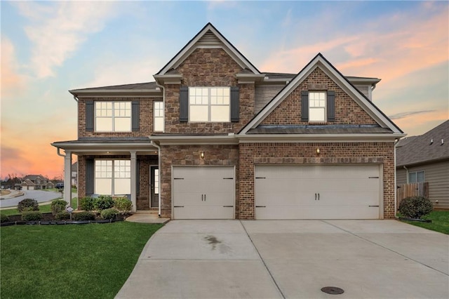 craftsman house with an attached garage, brick siding, stone siding, driveway, and a front yard