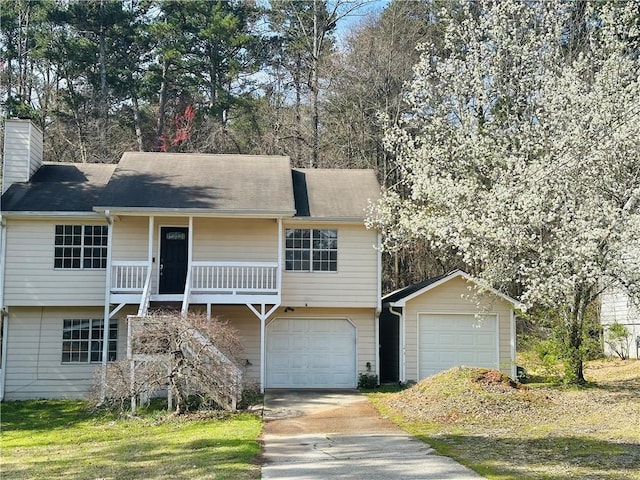 view of front facade with concrete driveway, an attached garage, and a chimney