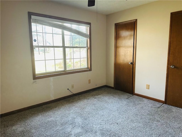 spare room featuring baseboards, a ceiling fan, and carpet flooring