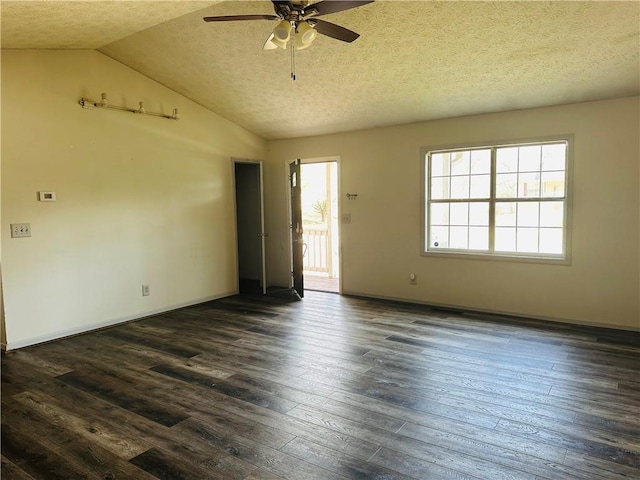 spare room featuring a textured ceiling, lofted ceiling, ceiling fan, and dark wood-style flooring