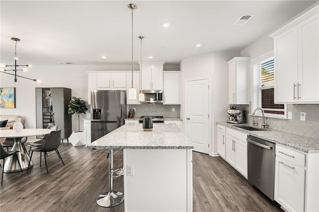 1590 Ridgebrook Downs, Mableton, GA 30126 - kitchen featuring stainless steel appliances, a sink, tasteful backsplash, a center island, and dark wood-style floors
