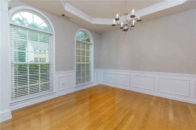 118 Brendylynn Trce, Woodstock, GA 30188 - empty room featuring a chandelier, a raised ceiling, ornamental molding, light wood finished floors, and a wainscoted wall