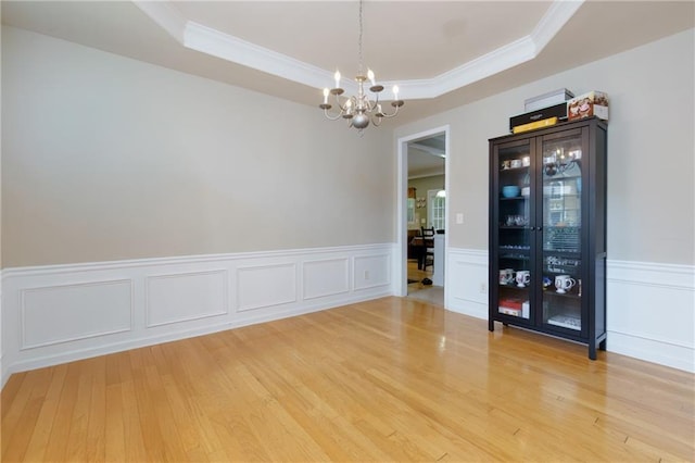 118 Brendylynn Trce, Woodstock, GA 30188 - empty room featuring a tray ceiling, a chandelier, crown molding, wood finished floors, and a wainscoted wall