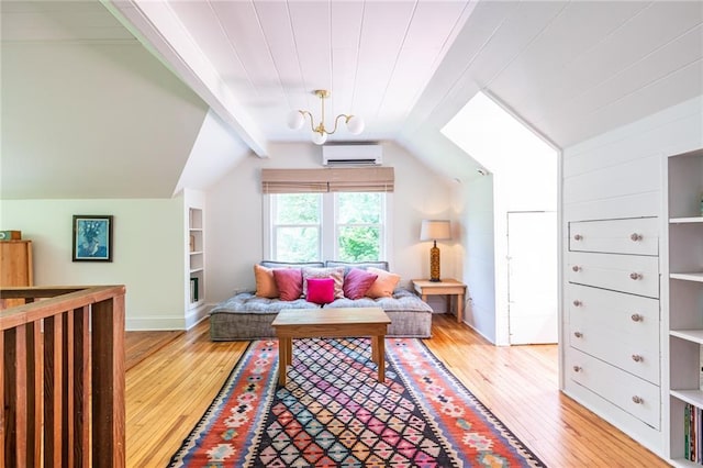 sitting room with light wood-type flooring, an AC wall unit, and baseboards