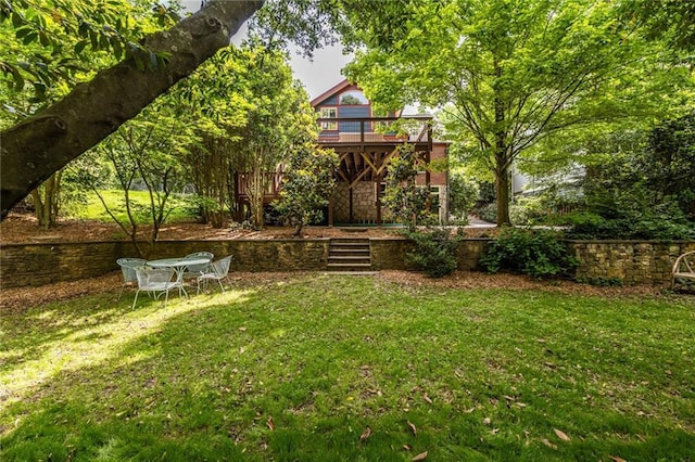view of green lawn featuring a deck and stairs