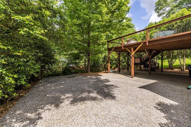 view of patio featuring stairway, a wooden deck, and fence