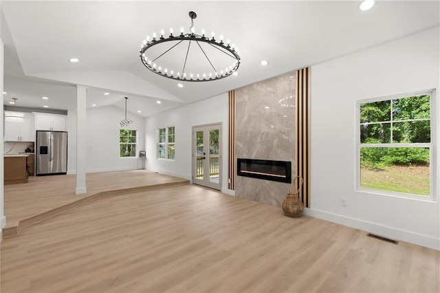 unfurnished living room featuring light wood-style floors, recessed lighting, a fireplace, vaulted ceiling, and baseboards