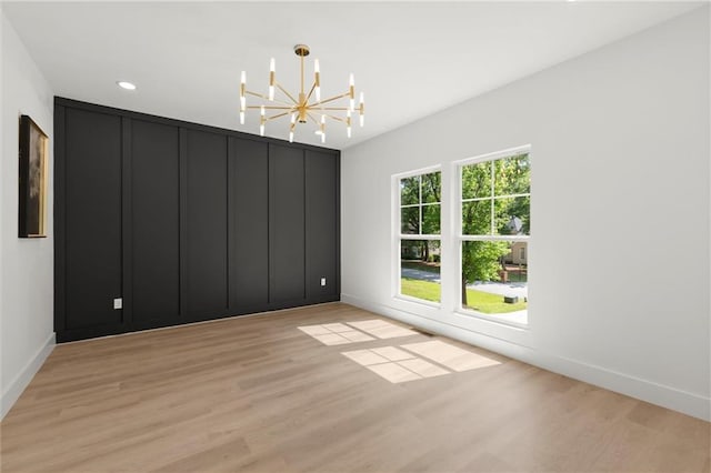 empty room with light wood-style floors, a chandelier, baseboards, and recessed lighting