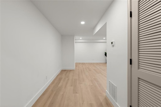 corridor with light wood-style floors, recessed lighting, and baseboards