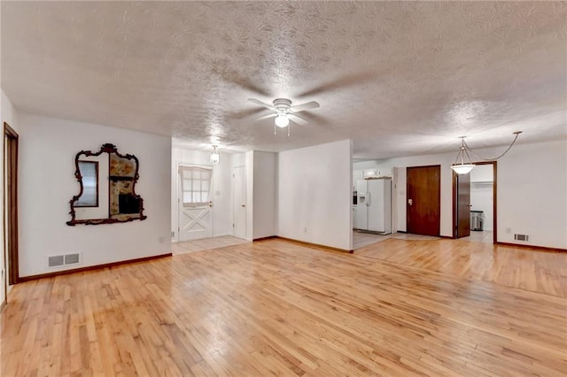 unfurnished living room featuring ceiling fan, a textured ceiling, and light hardwood / wood-style floors