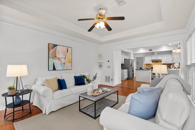 3242 Monarch Pine Dr, Peachtree Corners, GA 30071 - living room featuring a tray ceiling, crown molding, wood finished floors, ceiling fan, and baseboards