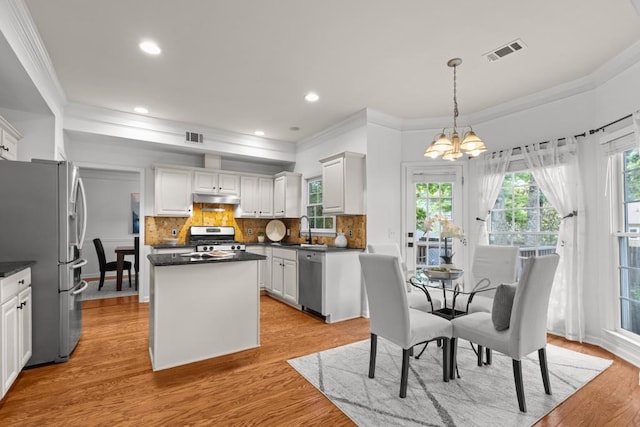 3242 Monarch Pine Dr, Peachtree Corners, GA 30071 - kitchen featuring appliances with stainless steel finishes, a chandelier, crown molding, a center island, and dark countertops