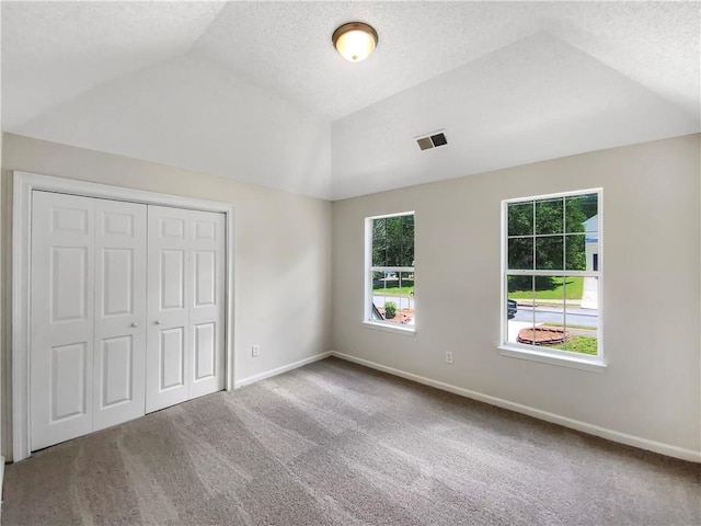 5159 Round Table Dr, Ellenwood, GA 30294 - unfurnished bedroom with vaulted ceiling, carpet flooring, a closet, and a textured ceiling