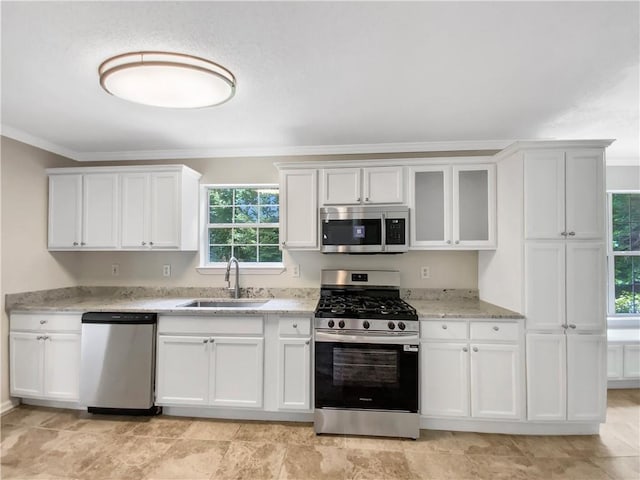 5159 Round Table Dr, Ellenwood, GA 30294 - kitchen featuring stainless steel appliances, crown molding, light stone countertops, white cabinetry, and glass insert cabinets