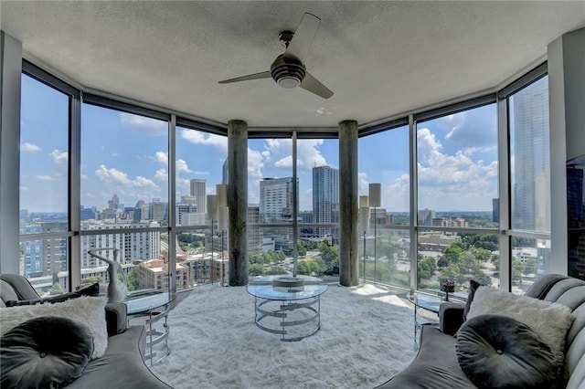 285 Centennial Olympic Park Dr NW Unit 1905, Atlanta, GA 30339 - living room featuring a view of skyline, expansive windows, ceiling fan, healthy amount of natural light, and a textured ceiling