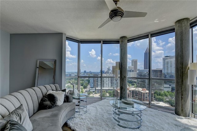 285 Centennial Olympic Park Dr NW Unit 1905, Atlanta, GA 30339 - living room with floor to ceiling windows, a view of skyline, a ceiling fan, plenty of natural light, and a textured ceiling