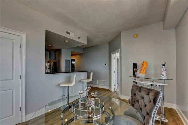 285 Centennial Olympic Park Dr NW Unit 1905, Atlanta, GA 30339 - dining area with a textured ceiling and wood finished floors