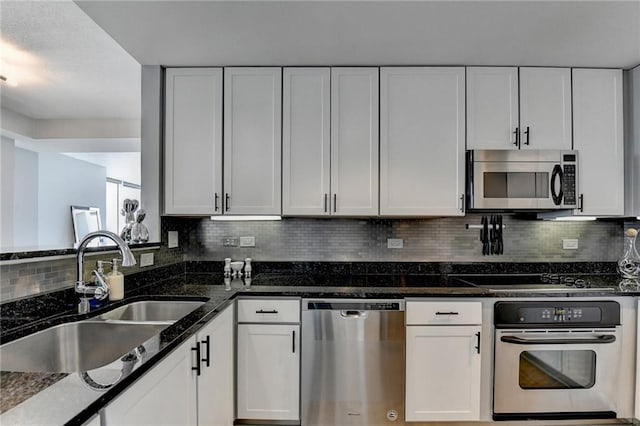 285 Centennial Olympic Park Dr NW Unit 1905, Atlanta, GA 30339 - kitchen with appliances with stainless steel finishes, white cabinetry, and dark stone counters