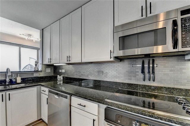 285 Centennial Olympic Park Dr NW Unit 1905, Atlanta, GA 30339 - kitchen featuring stainless steel appliances, backsplash, dark stone counters, and white cabinetry